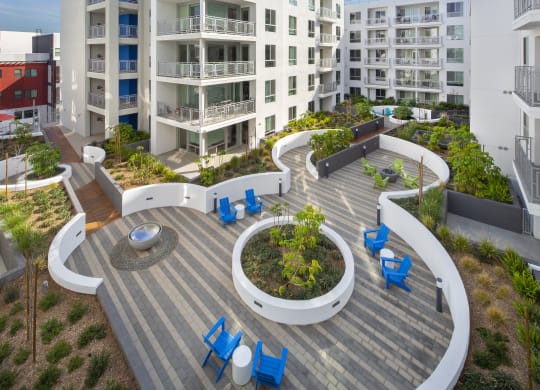 Apartments in Woodland Hills, CA - The Q Variel - Outdoor Courtyard with Chairs, Tables, Beautiful Landscaping, and Views of Patios/Balconies
