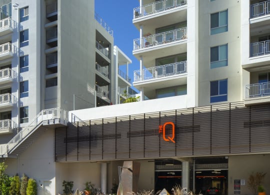 2 Bedroom Apartments in Woodland Hills, CA - The Q Variel - Property Exterior with a Parking Garage Entrance and Private Balconies