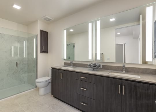 a bathroom with a large mirror and a toilet and a shower