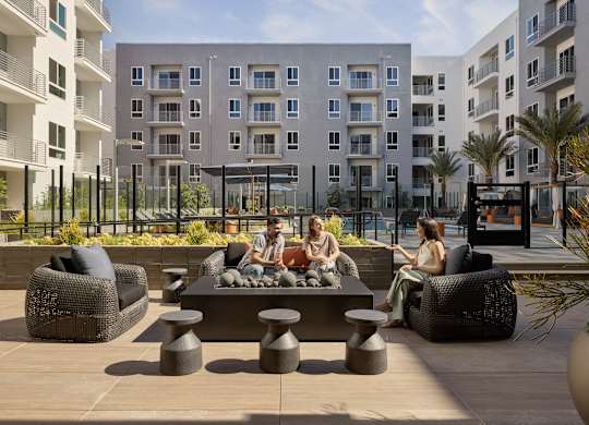 A group of people are sitting on a couch and chairs on a patio.