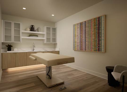 A room with a massage table and a chair.