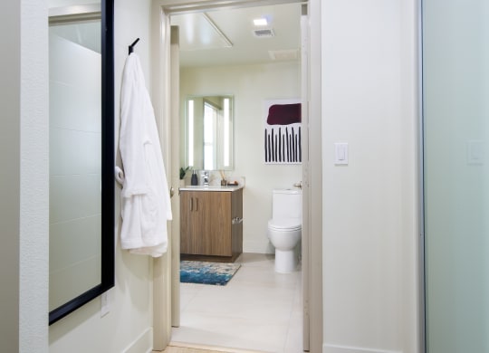 a white bathroom with a large mirror and a white toilet