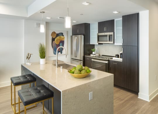 a kitchen with a large island with a bowl of fruit