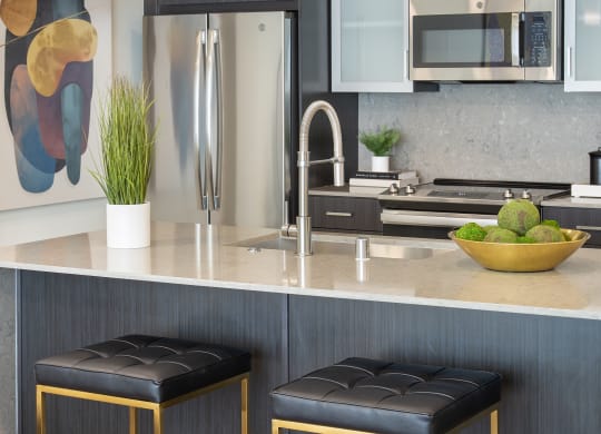 a kitchen with two stools in front of a counter