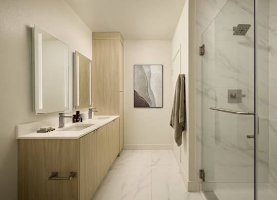 A bathroom with a white marble floor and a wooden vanity with two sinks.