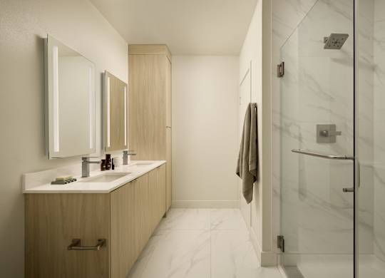 A bathroom with a marble floor and a wooden vanity.
