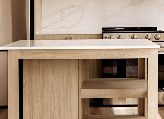 A kitchen with a wooden island and stove top.