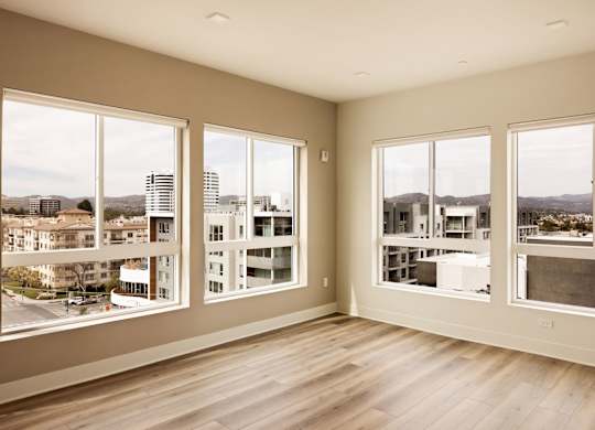 A room with large windows overlooking a cityscape.