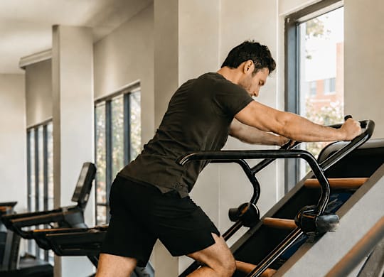 A man is using a treadmill in a gym.