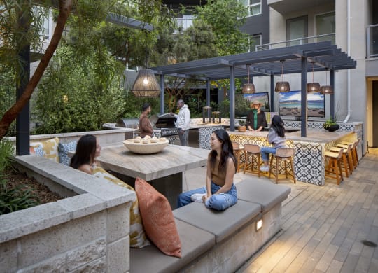 a group of people sitting on benches in an outdoor patio