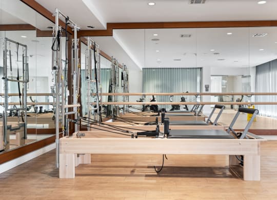 a row of weights machines in a room with mirrors