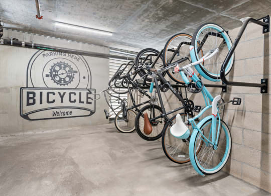a group of bikes hanging on a wall in a bike garage