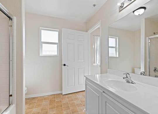 A bathroom with a white sink and a white door.