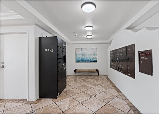 A room with a LUXE refrigerator and a painting of a beach scene on the wall.