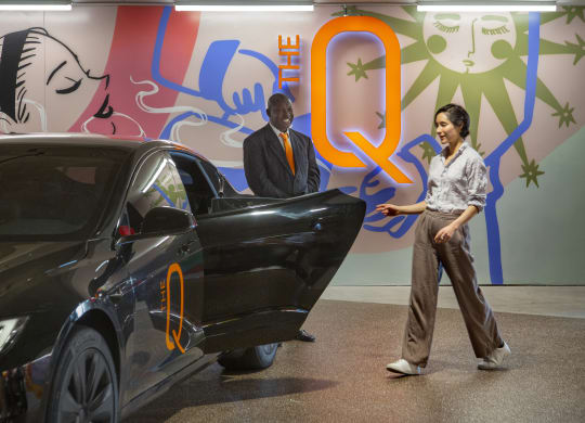 a man and a woman standing next to a black car