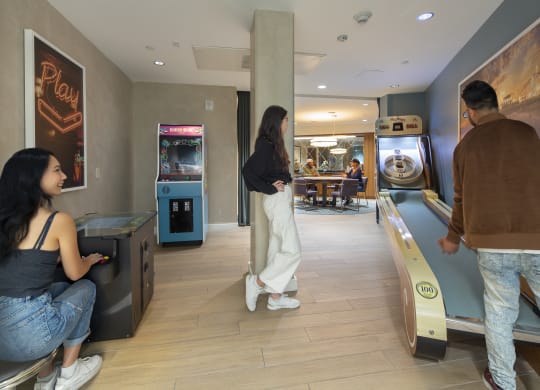 a man and a woman are standing in a room next to a bowling alley