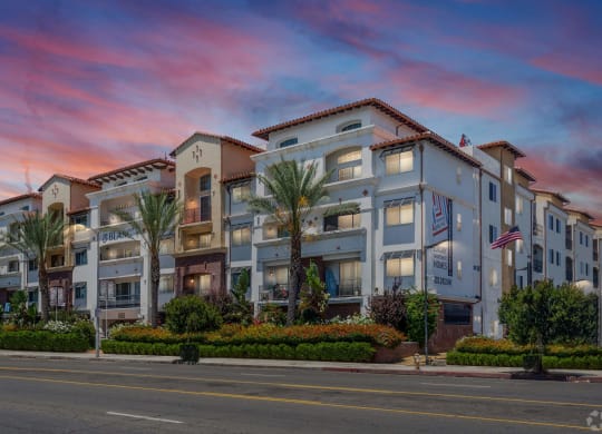 an apartment building on the corner of a street at sunset at Le Blanc Apartment Homes, Canoga Park, CA