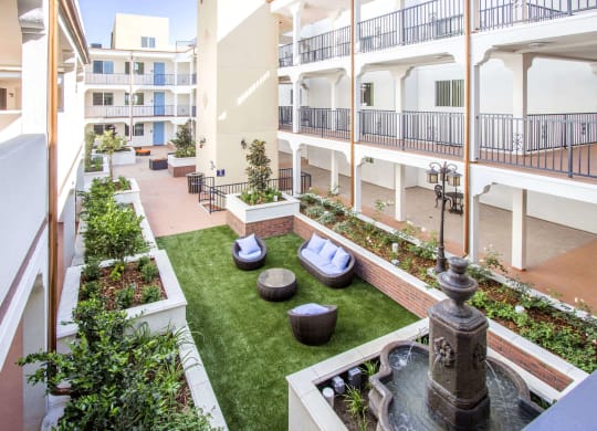 a courtyard with a fountain and green grass at Le Blanc Apartment Homes, California, 91304