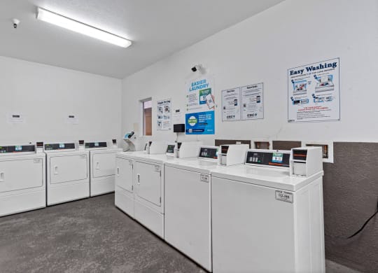 a row of washers and dryers in a laundromat with white machines at Dronfield Astoria, Sylmar, California