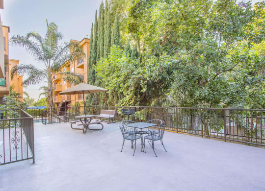 a patio with a table and chairs and a fence at Dronfield Astoria Apartments, CA, 91342