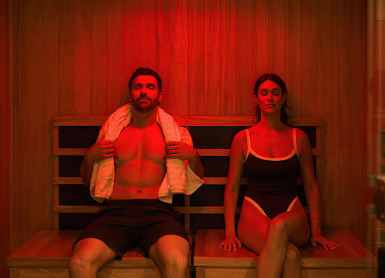 A man and a woman are sitting in a sauna.