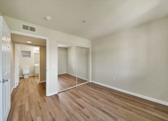 an empty living room with wood flooring and white walls
