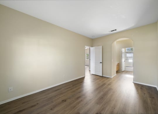 a bedroom with hardwood floors and beige walls at The Village Apartments, Van Nuys, 91406