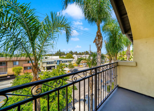 a balcony looking out onto palm trees at Toscana Apartments, Van Nuys, 91406