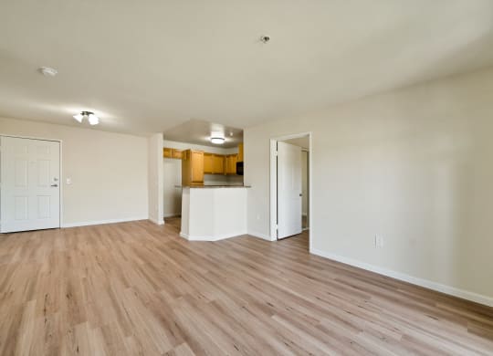an empty living room with a kitchen in the background at Toscana Apartments, California, 91406