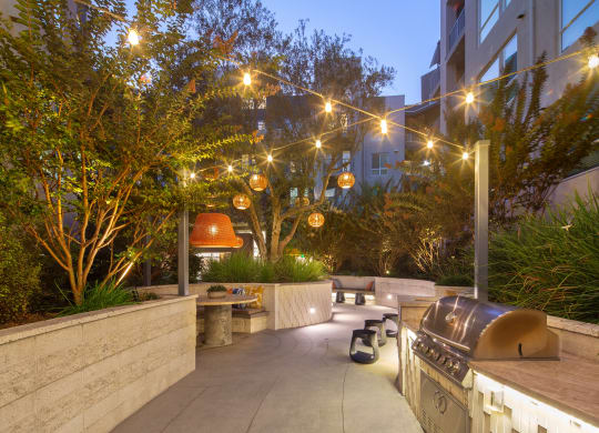 a patio with a barbecue grill and lights