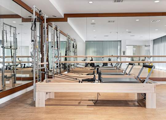 A pilates studio with mirrors on the wall.