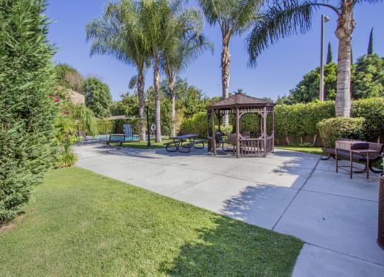 a park with a gazebo and benches and trees