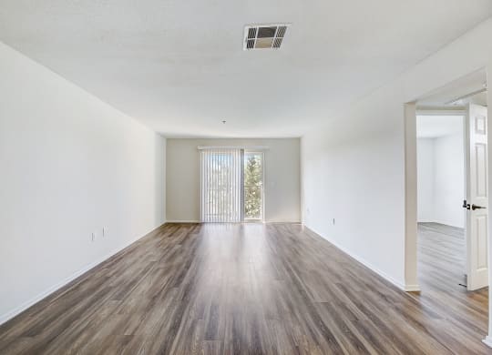 an empty living room with white walls and wood flooring