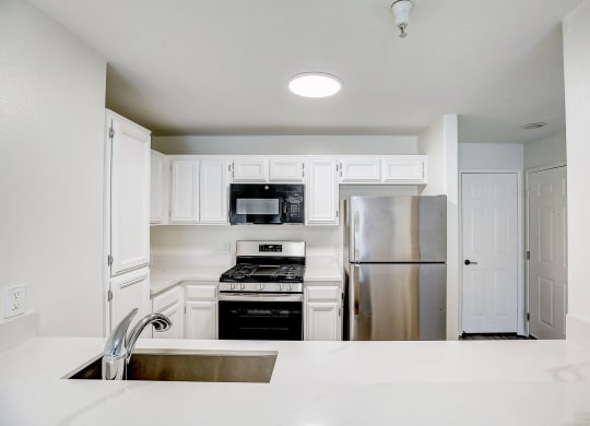 a kitchen with stainless steel appliances and white cabinets