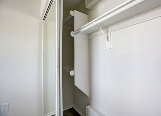 an empty closet with a white wall and a sliding glass door