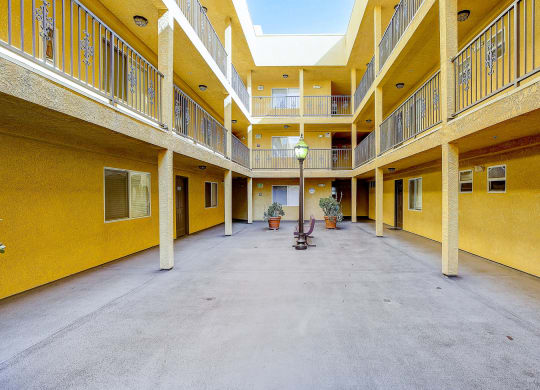 a courtyard with a lamp in the middle of a yellow building