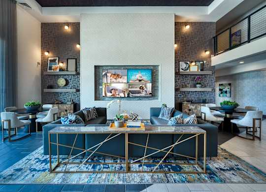 Resident clubhouse with a couch and a table at Cuvee, Glendale, AZ