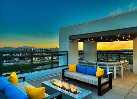 Rooftop patio with tables and chairs and firepit at dusk at Cuvee, Arizona