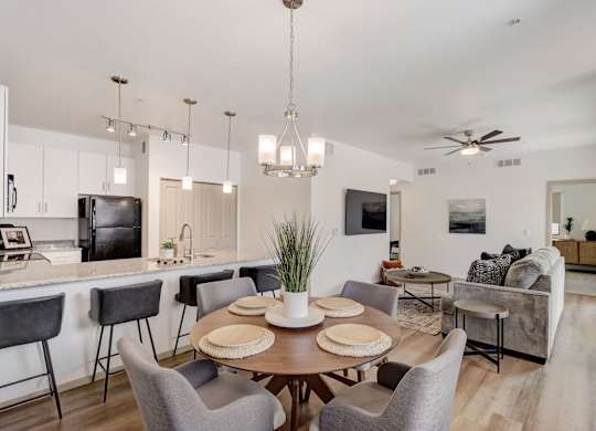 A modern dining room with a wooden table and grey chairs.