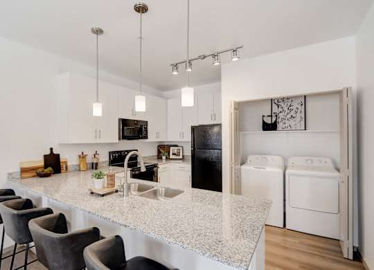 A kitchen with a white countertop and black appliances.