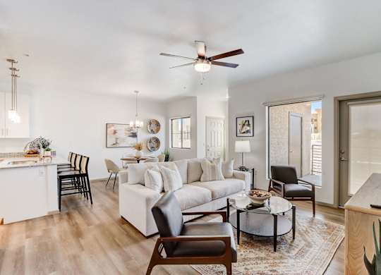 A living room with a white couch, a coffee table, and a ceiling fan.