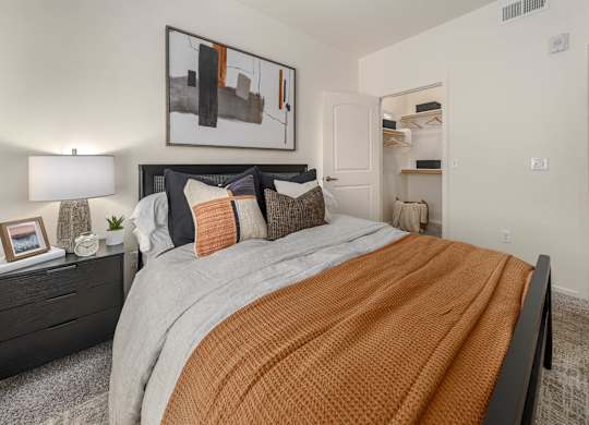A bedroom with a large bed and a painting on the wall.