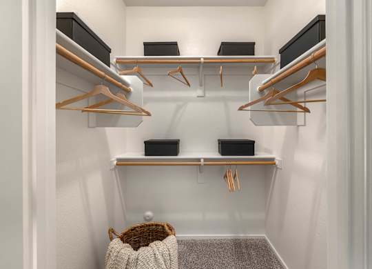 A small closet with a white background and a brown basket.