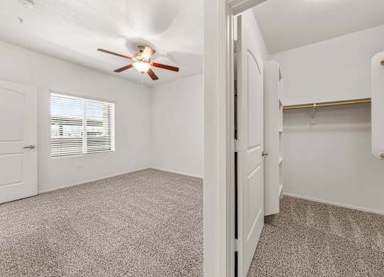 A room with a ceiling fan and carpeted floor.