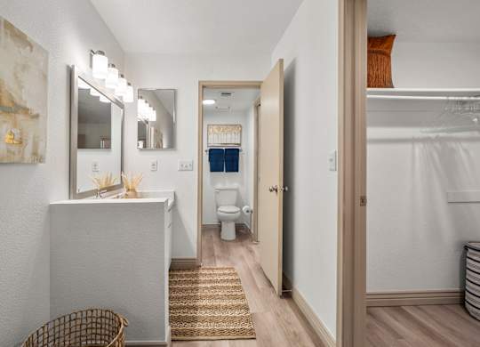A bathroom with a white vanity and a mirror above it.