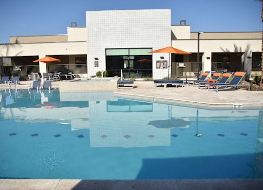 A swimming pool in front of a building with a white facade.