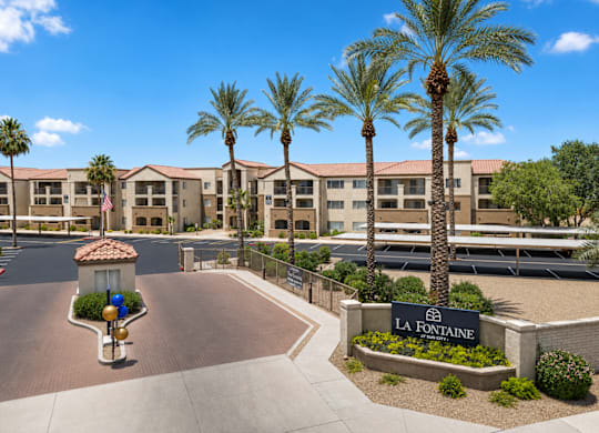 A sunny day at La Fontaine apartment complex with palm trees and a clear blue sky.