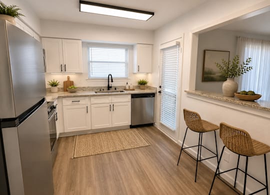 A kitchen with white cabinets and a stainless steel refrigerator.