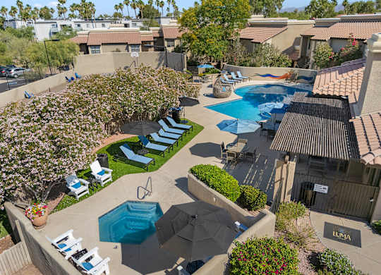 A pool surrounded by chairs and umbrellas.