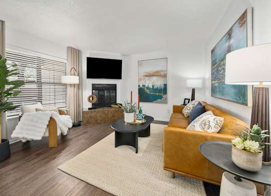 A living room with a fireplace, a couch, and a painting on the wall.